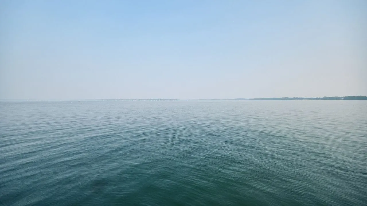 City skyline across Lake Monona in Madison, Wisconsin, dimmed to gray silhouettes by wildfire smoke haze
