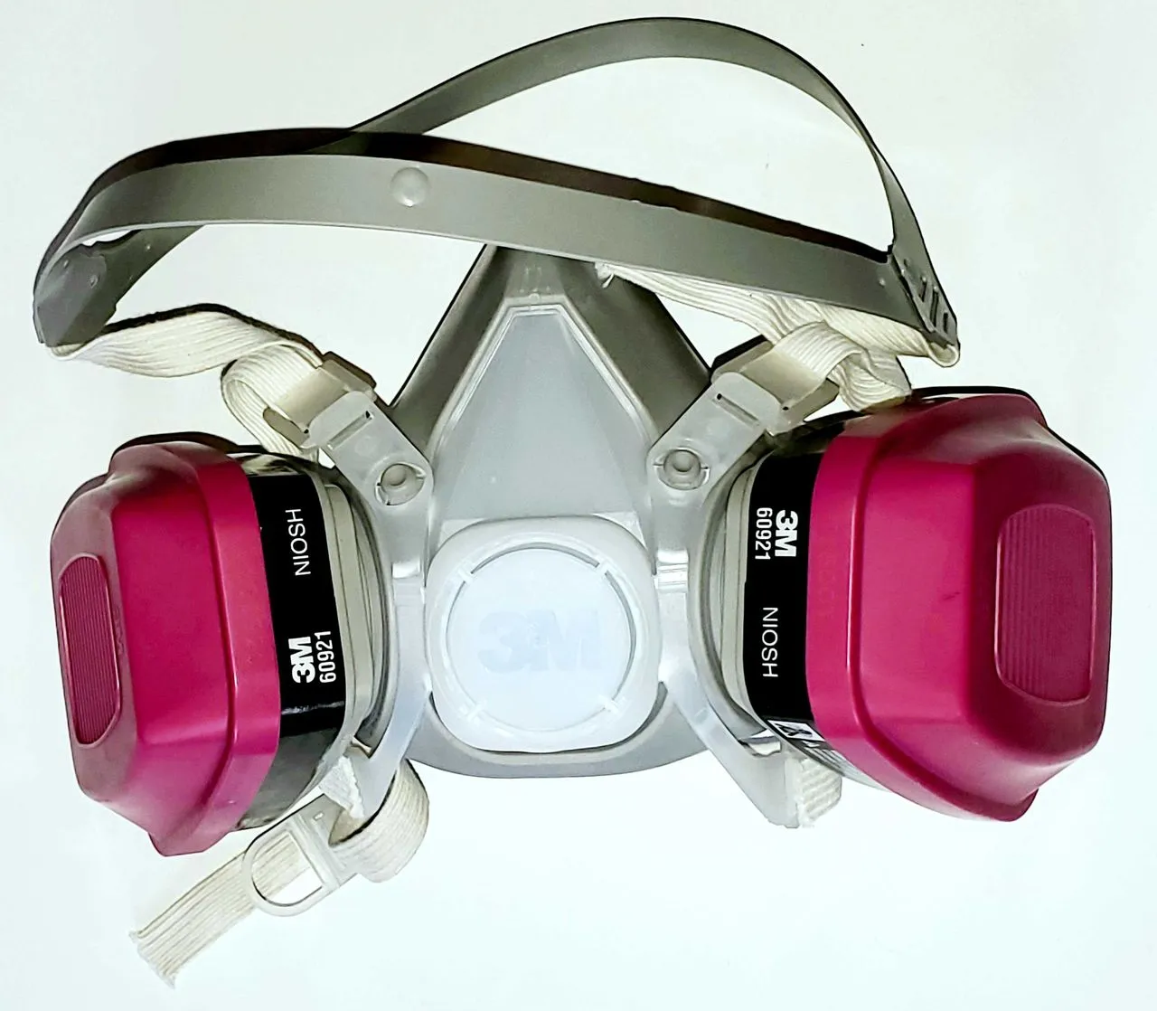 Half-face respirator with twin filter cartridges photographed on a plain neutral background